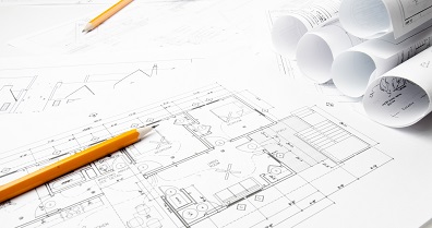 Construction planning drawings on the table and two yellow pencils