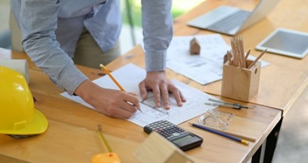 The architect is designing the construction. He drafts the floor plan to present to the client.